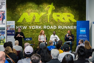 Three athletes speak on a panel in front of an audience at NYRR's Run Center